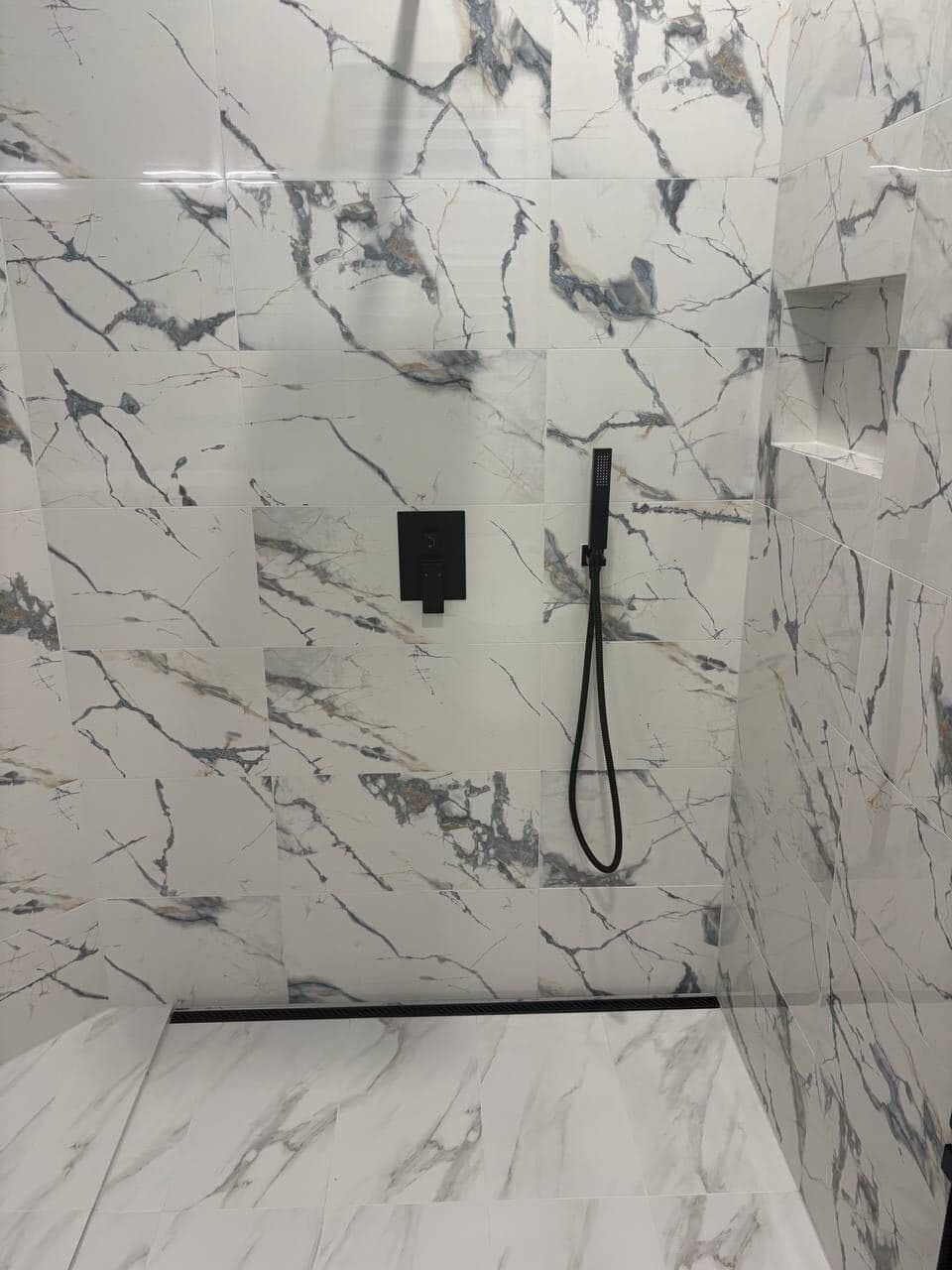 Completed walk-in shower with marble-veined porcelain tile and matte black fixtures