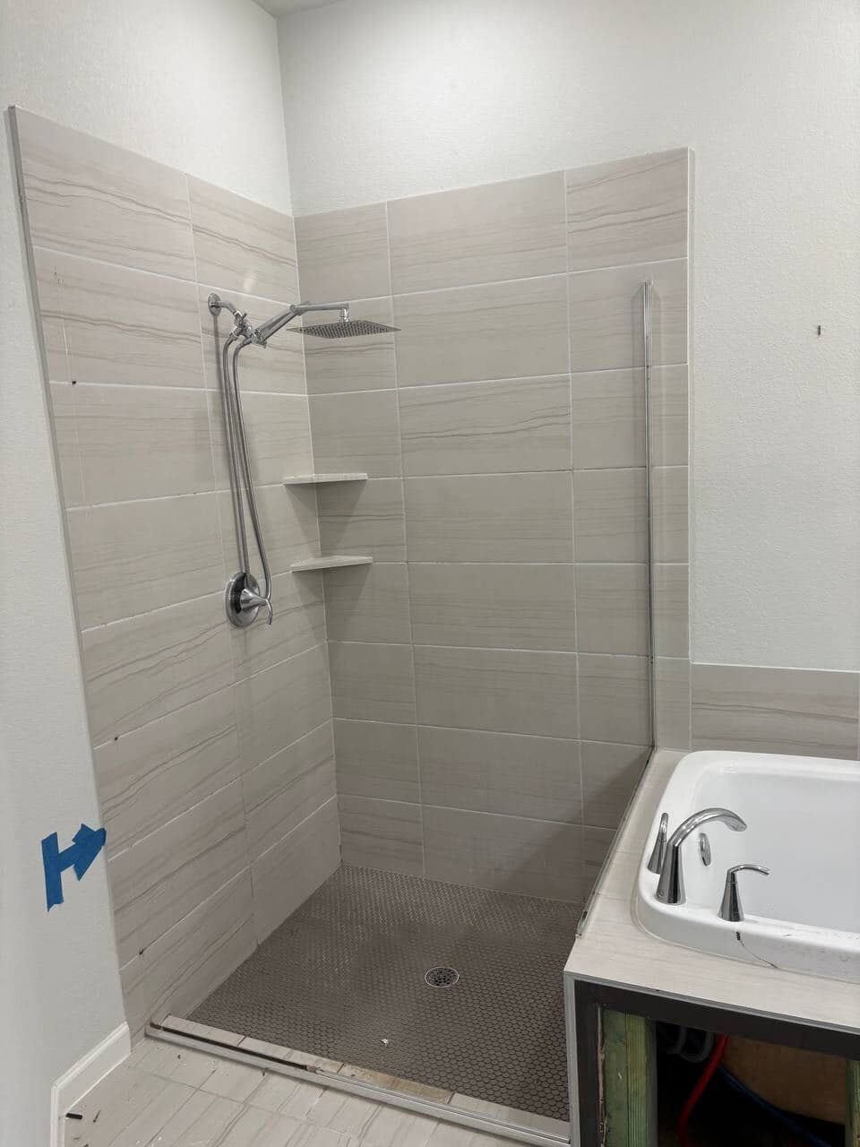 Bathroom before remodeling with basic tile and unfinished vanity