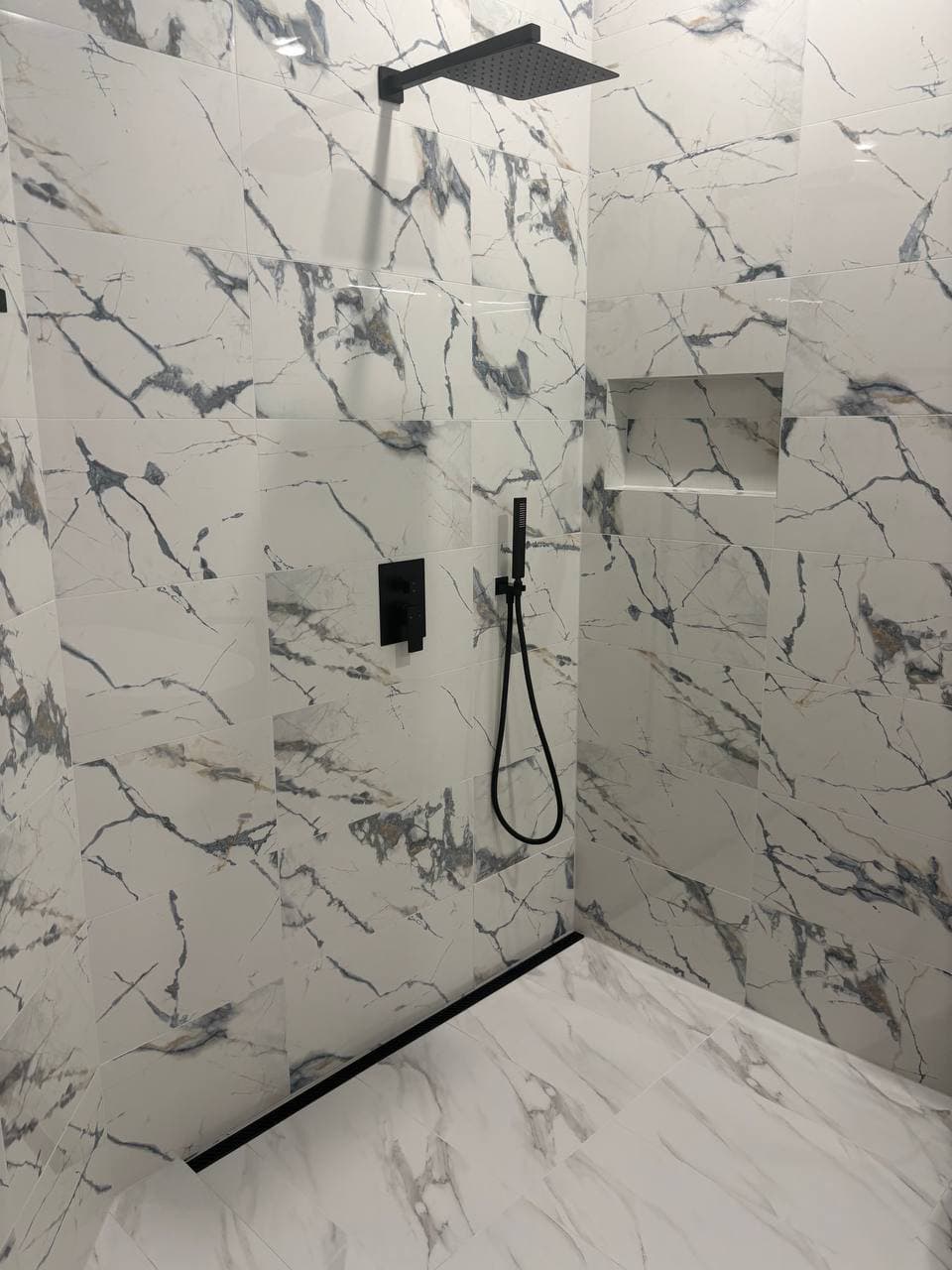 Walk-in shower with marble tile and matte black fixtures in Dallas