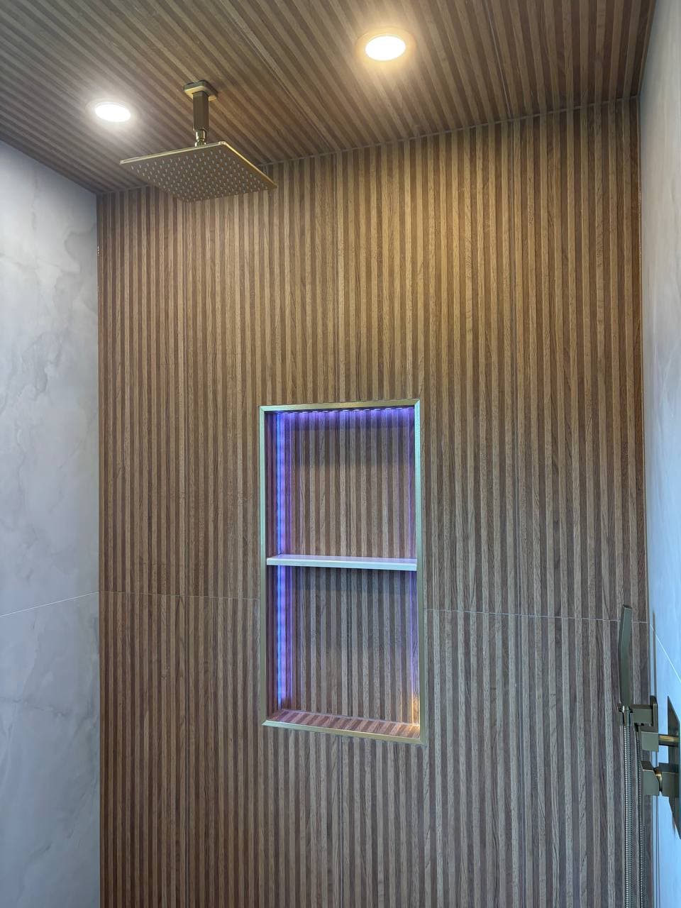 Spa-inspired shower with wood slat panels and LED niche in Allen TX